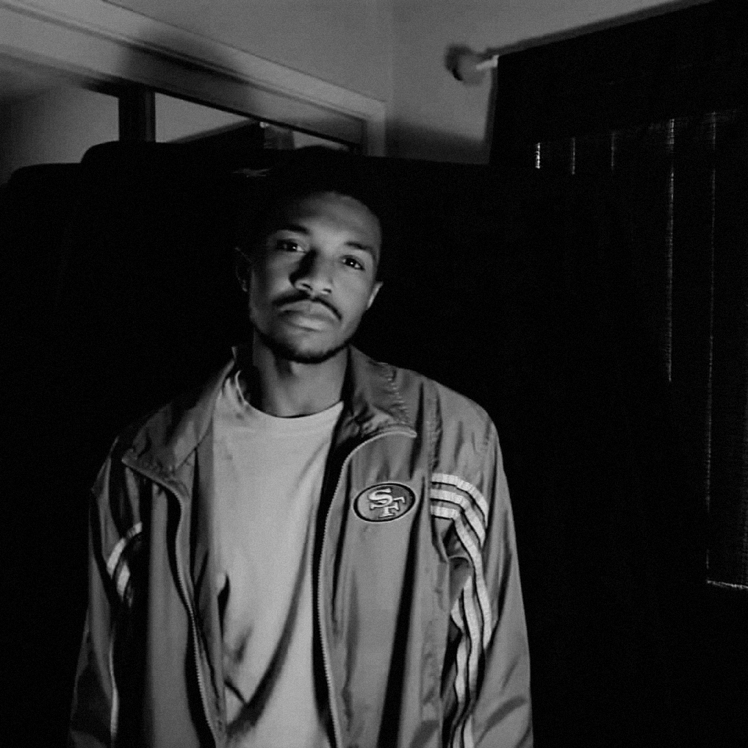 A professional close up portrait of is ali looking directly at the camera with a neutral expression