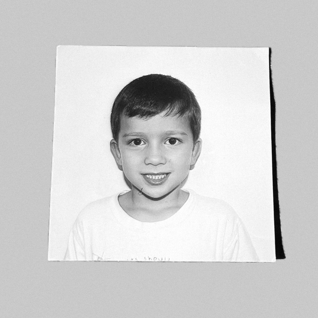 A black and white portrait photo of a smiling young boy named Owen Carson