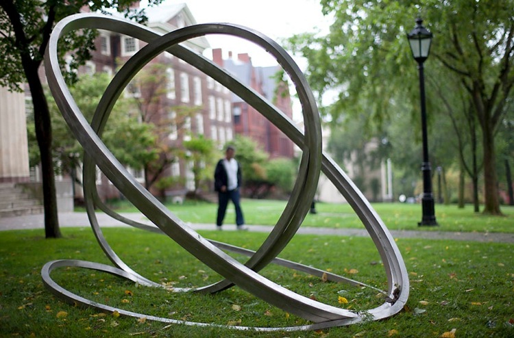 outside image of three large metal rings on a grassy lawn