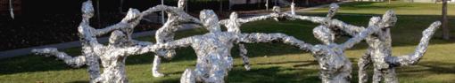 sculpture outdoors of metallic figures dancing in a circle