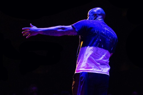 Chachi Carvalho on stage holding a microphone.