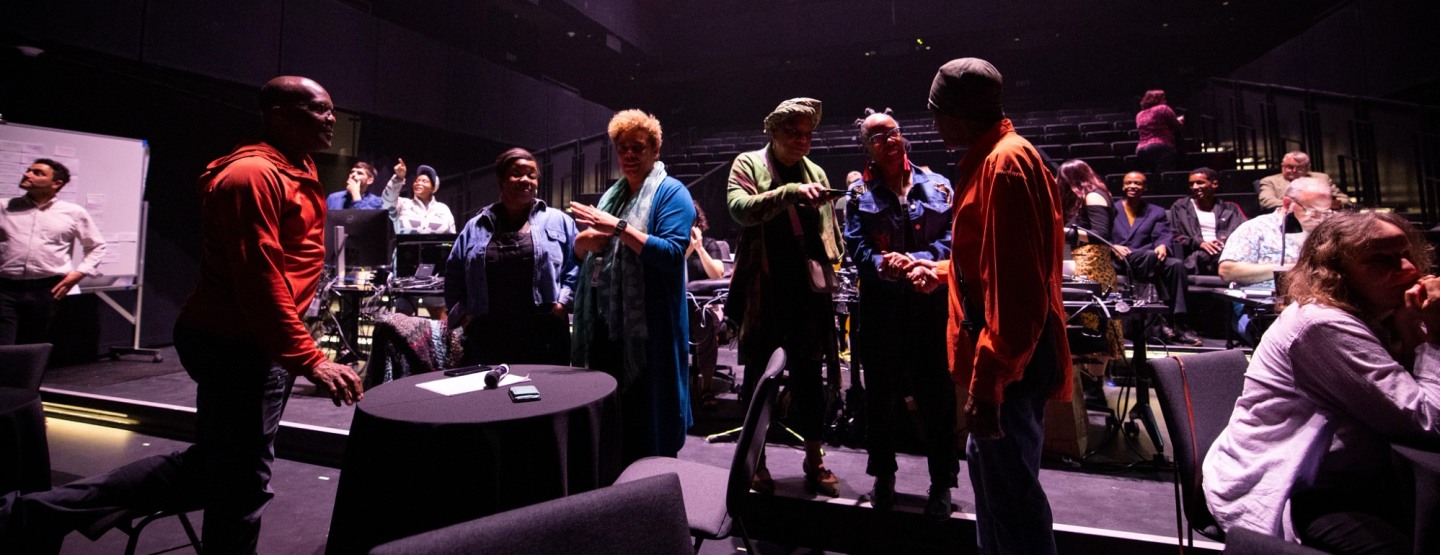 Performing artists are rehearsing and discussing for the formal performance.