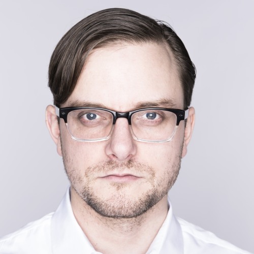 Headshot of Sydney Skybetter. He is a white man with a beard, dark hair, wearing glasses.