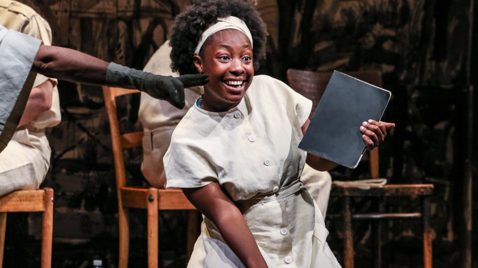 A young woman dances while holding a book.