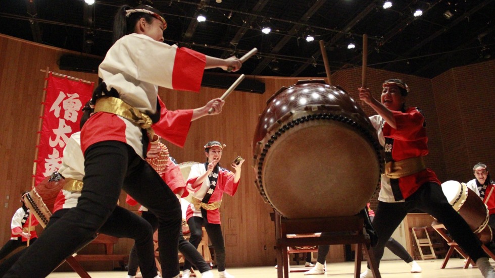 Taiko drummers perform on a stage