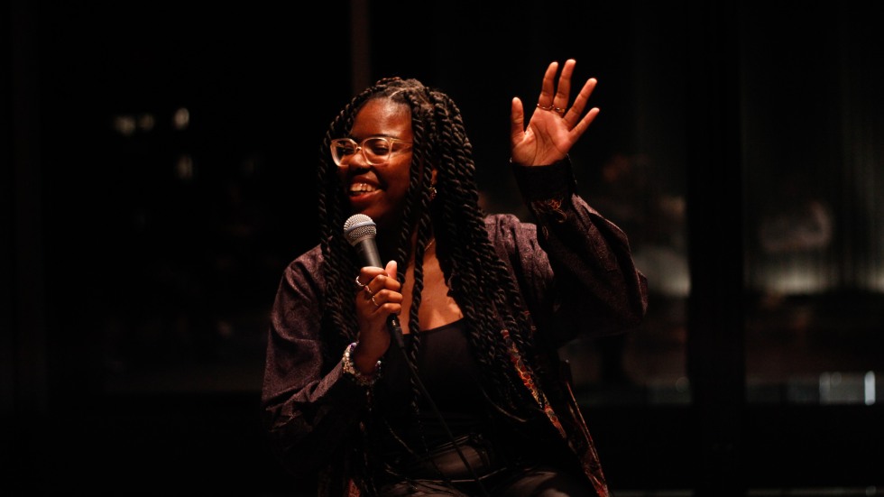 woman with microphone and hand raised up