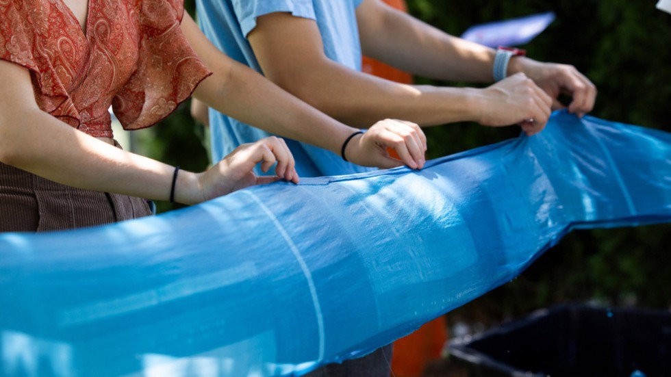 blue silk cyanotype held to dry by participants 