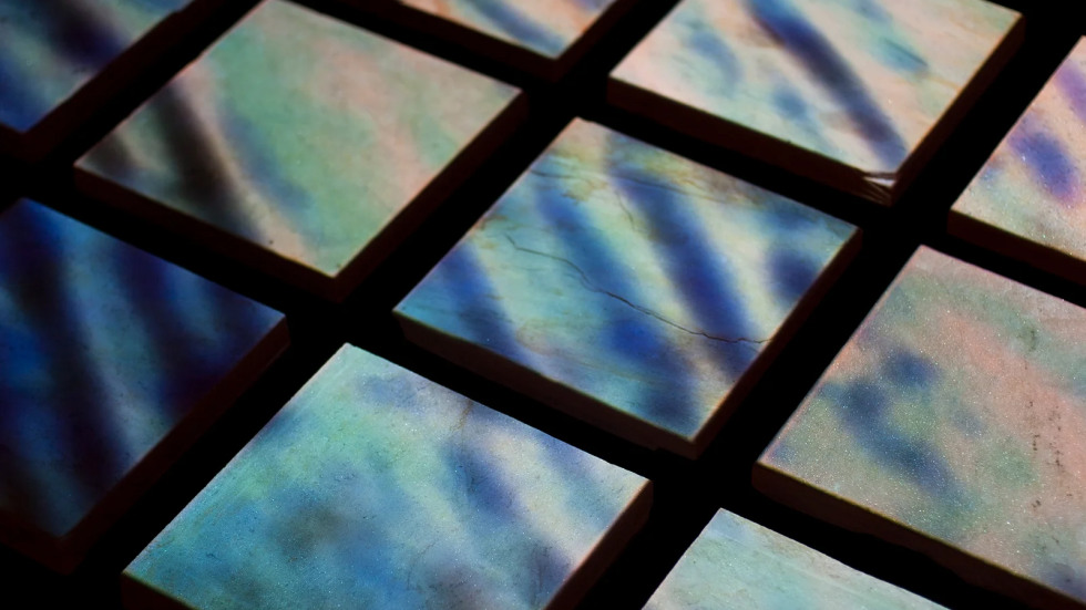 A grid of twelve square panels featuring iridescent teal and purple textured surfaces with diagonal light streaks set against a solid black background