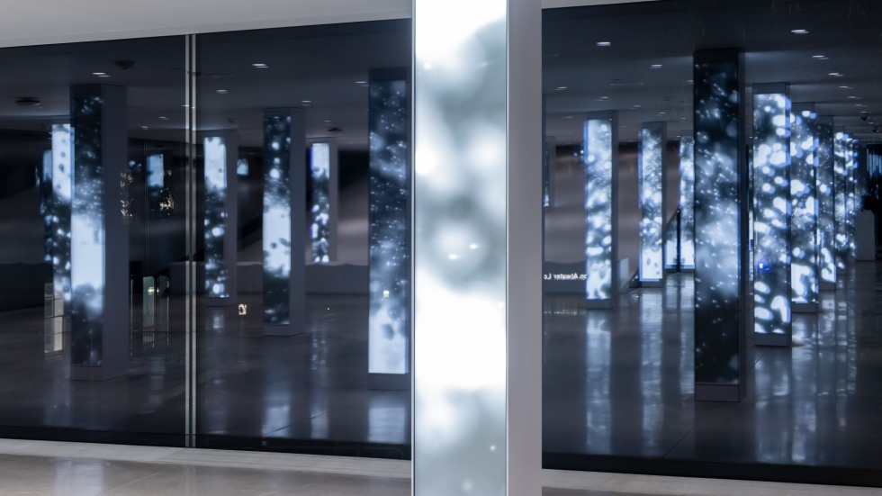 glowing light patterns on columns reflected infinitely in glass walls at night