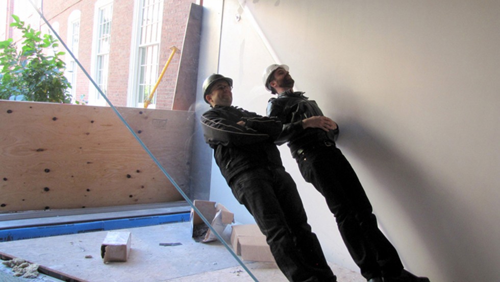 two workers lying on installation during install